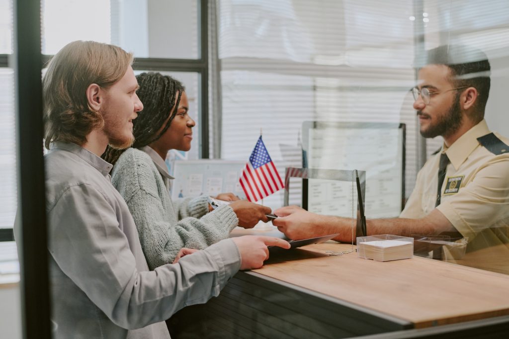 Diverse Couple Handing Passports at Immigration Office